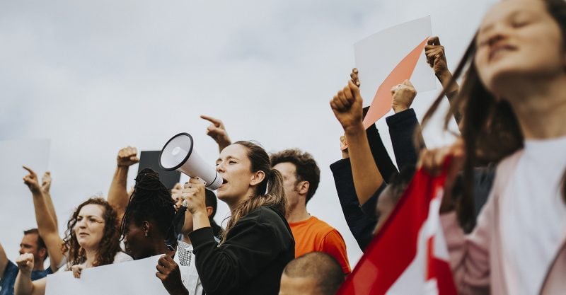 Image of people at a rally and a woman speaking with a megaphone