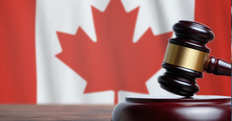 Justice and court concept in Canada. Judge hammer on a flag background
