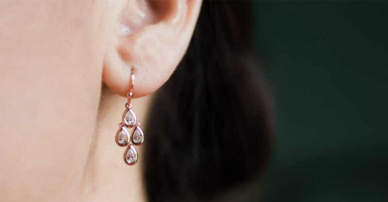 Up close photo of woman with an earring in her ear.