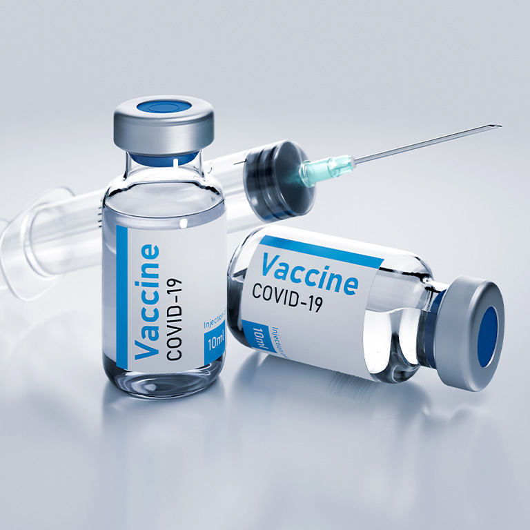 COVID-19 Vaccine vials and a needle.