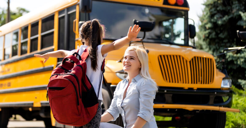 mom and daughter in front of school bus