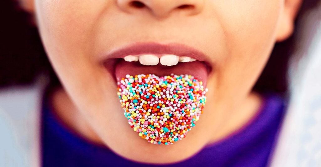 child with sprinkles on tongue