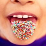 child with sprinkles on tongue