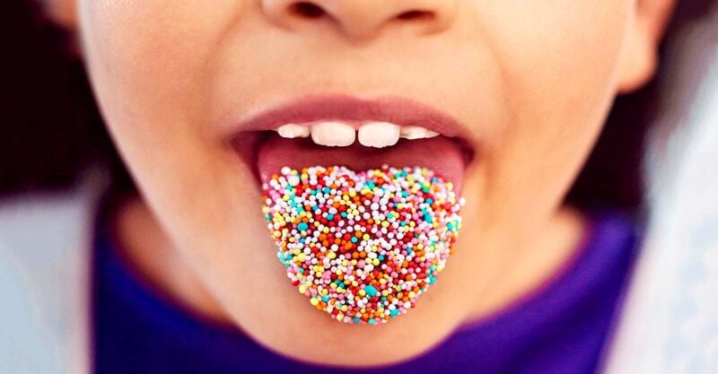 child with sprinkles on tongue