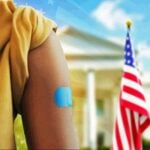 child with arm band aid and white house