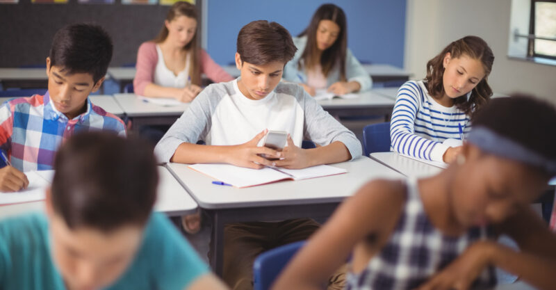 Student using mobile phone in classroom