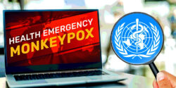 computer with "health emergency monkeypox" words on it and WHO logo inside magnifying glass