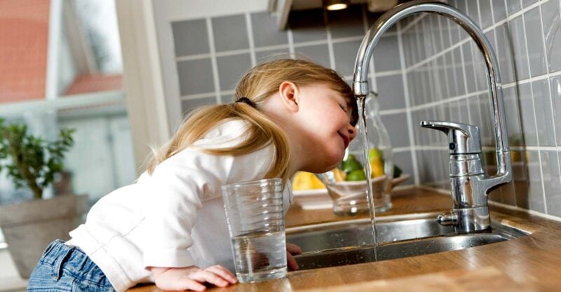girl drinking tap water from faucet