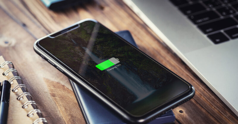 black smart phone charging on external wireless charger