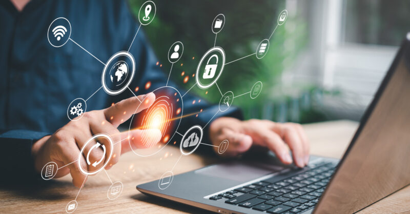 Fingerprint scanning and biometric authentication concept image. Man at laptop computer using fingerprint.