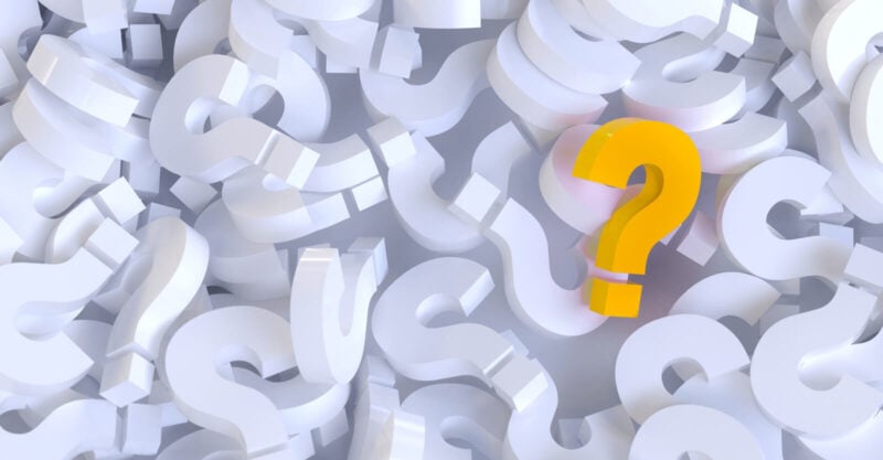 A pile of white question marks and one yellow one.